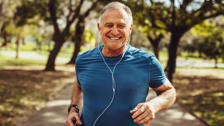 man in blue shirt running while smiling