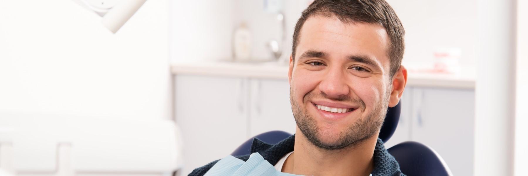 man smiling in dental chair after dental exam in urbandale